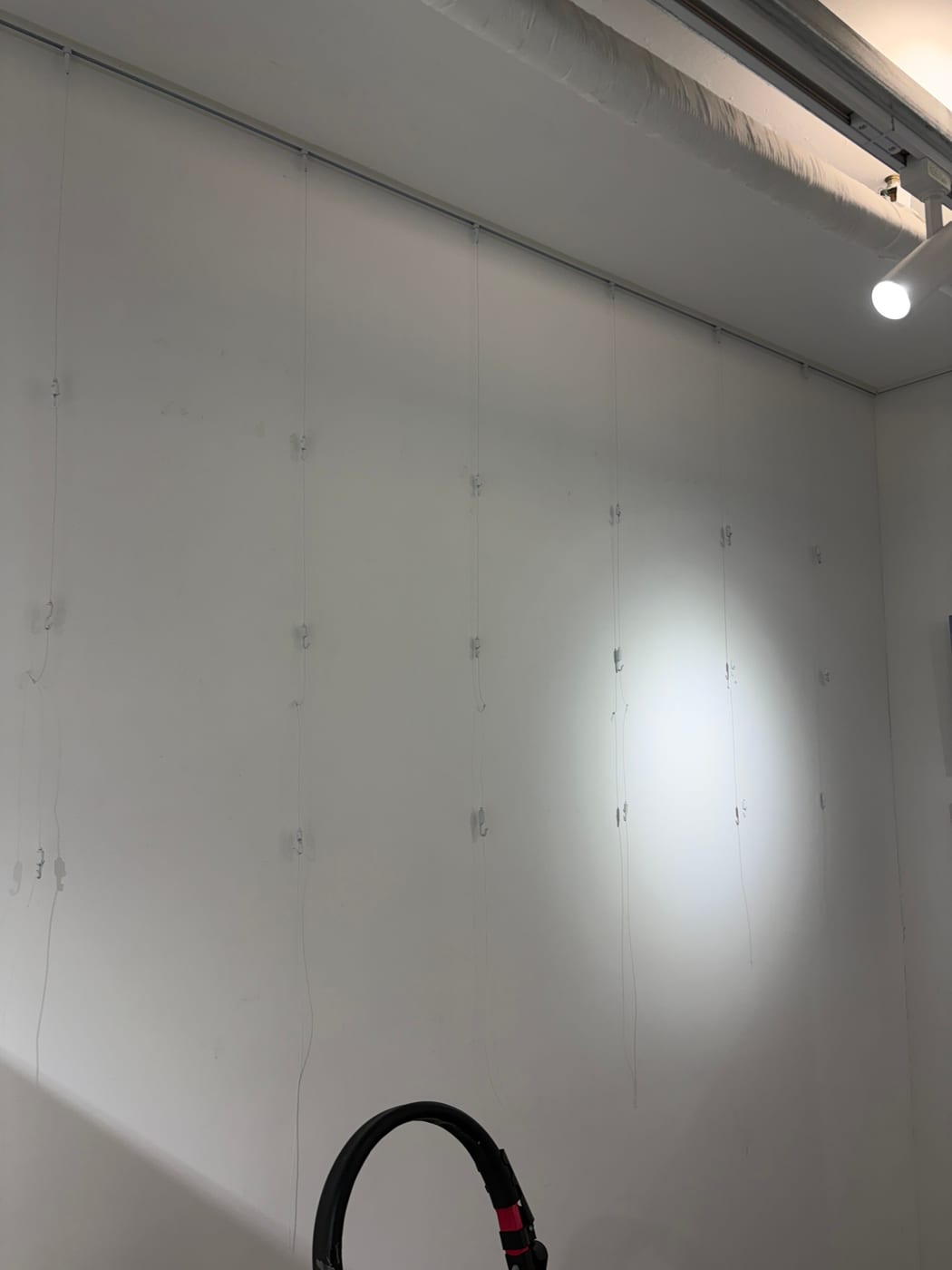 액자를 걸기 전 벽을 따라 와이어와 후크를 내려 둔 상태